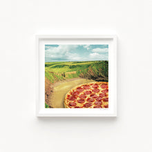 Charger l'image dans la galerie, A surreal art print of a pepperoni pizza seamlessly blending into a coastal bay landscape with rolling green cliffs and a sandy shore. Coastal Art
