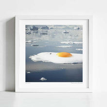Cargar imagen en el visor de la galería, Surrealist artwork titled "Egg-berg" featuring a sunny-side-up egg on a melting iceberg. This piece by Vertigo Artography combines environmental themes with whimsical imagery, perfect for contemporary art collectors. Explore the fusion of reality and imagination with "Egg-berg," a striking addition to any modern art collection. Buy now to own a piece that sparks conversation and visual delight.