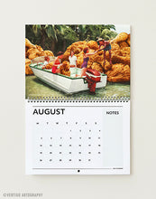 Load image into Gallery viewer, August page of the 2027 Vertigo Artography wall calendar, retro women in a speedboat among giant fried chicken rocks, funny surreal food art