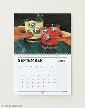 Load image into Gallery viewer, September page of the 2027 surreal art calendar, two hands toasting cocktails with disco ball ice cubes against a starry galaxy
