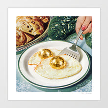 Load image into Gallery viewer, Surreal art print of a fried egg on a white diner plate with two gold glittering disco ball yolks, held by a spatula – Disco Eggs by Vertigo Artography